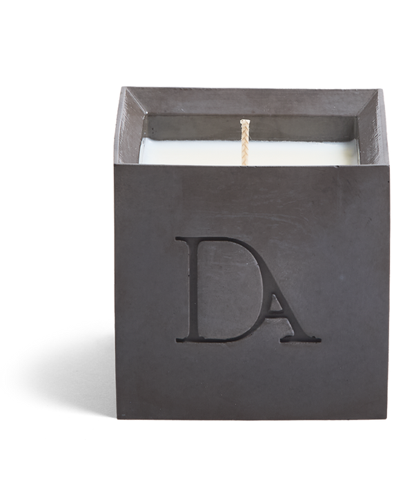 9oz Devetu artisanal candle in Apollo, crafted in a gunmetal black concrete square vessel. The candle is uncovered, displaying the richly textured wax surface, with the 'DA' Devetu Aroma logo embossed on the front.