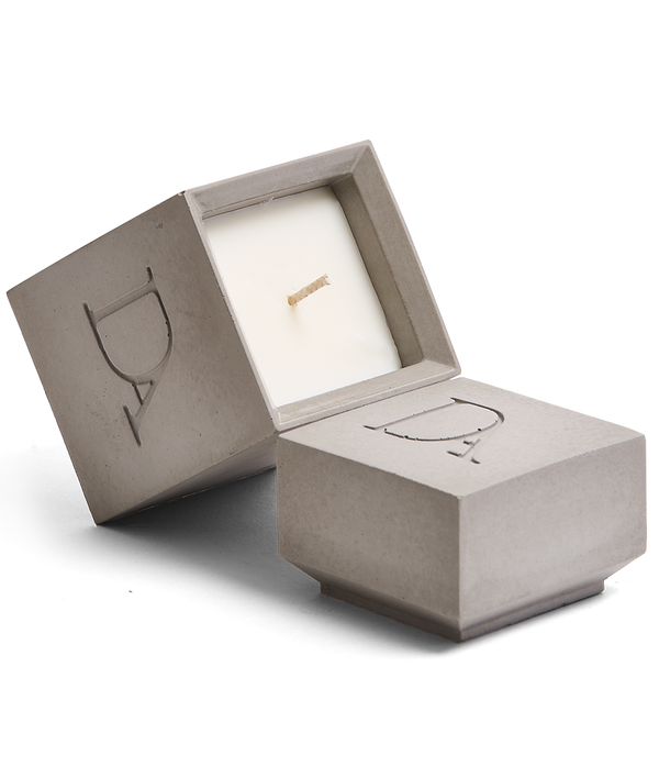 4oz Devetu artisanal candle in Odyssey, encased in ash grey concrete square vessel with a lid. The lid, featuring the embossed 'DA' Devetu Aroma logo, adds a sleek finish to the candle's modern aesthetic.