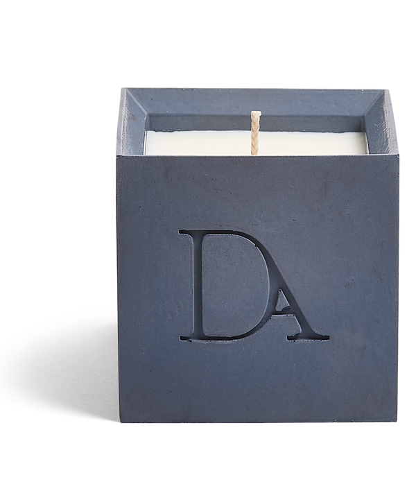 9oz Devetu artisanal candle in Elysian, crafted in a deep navy concrete square vessel. The candle is uncovered, displaying the richly textured wax surface, with the 'DA' Devetu Aroma logo embossed on the front.