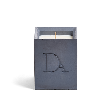 4oz Devetu artisanal candle in Elysian, crafted in a deep navy concrete square vessel. The candle is uncovered, displaying the richly textured wax surface, with the 'DA' Devetu Aroma logo embossed on the front.