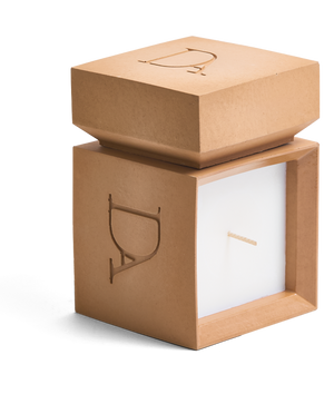 9oz Devetu artisanal candle in Embrace, encased in warm cashew colored concrete square vessel with a lid. The lid, featuring the embossed 'DA' Devetu Aroma logo, adds a sleek finish to the candle's modern aesthetic.