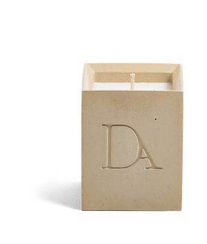 4oz Devetu artisanal concrete square candle named Gravity in soft taupe, uncovered, showcasing the richly textured wax surface, with ‘DA’ Devetu Aroma logo embossed on the front.