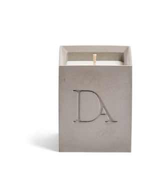 4oz Devetu artisanal concrete square candle named Odyssey in ash grey, uncovered, showcasing the richly textured wax surface, with ‘DA’ Devetu Aroma logo embossed on the front.