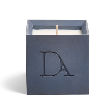 9oz Devetu artisanal candle in Elysian, crafted in a deep navy concrete square vessel. The candle is uncovered, displaying the richly textured wax surface, with the 'DA' Devetu Aroma logo embossed on the front.