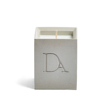 4oz Devetu artisanal concrete square candle named Skin, uncovered, showcasing the richly textured wax surface, in a natural concrete gray with ‘DA’ Devetu Aroma logo embossed on the front